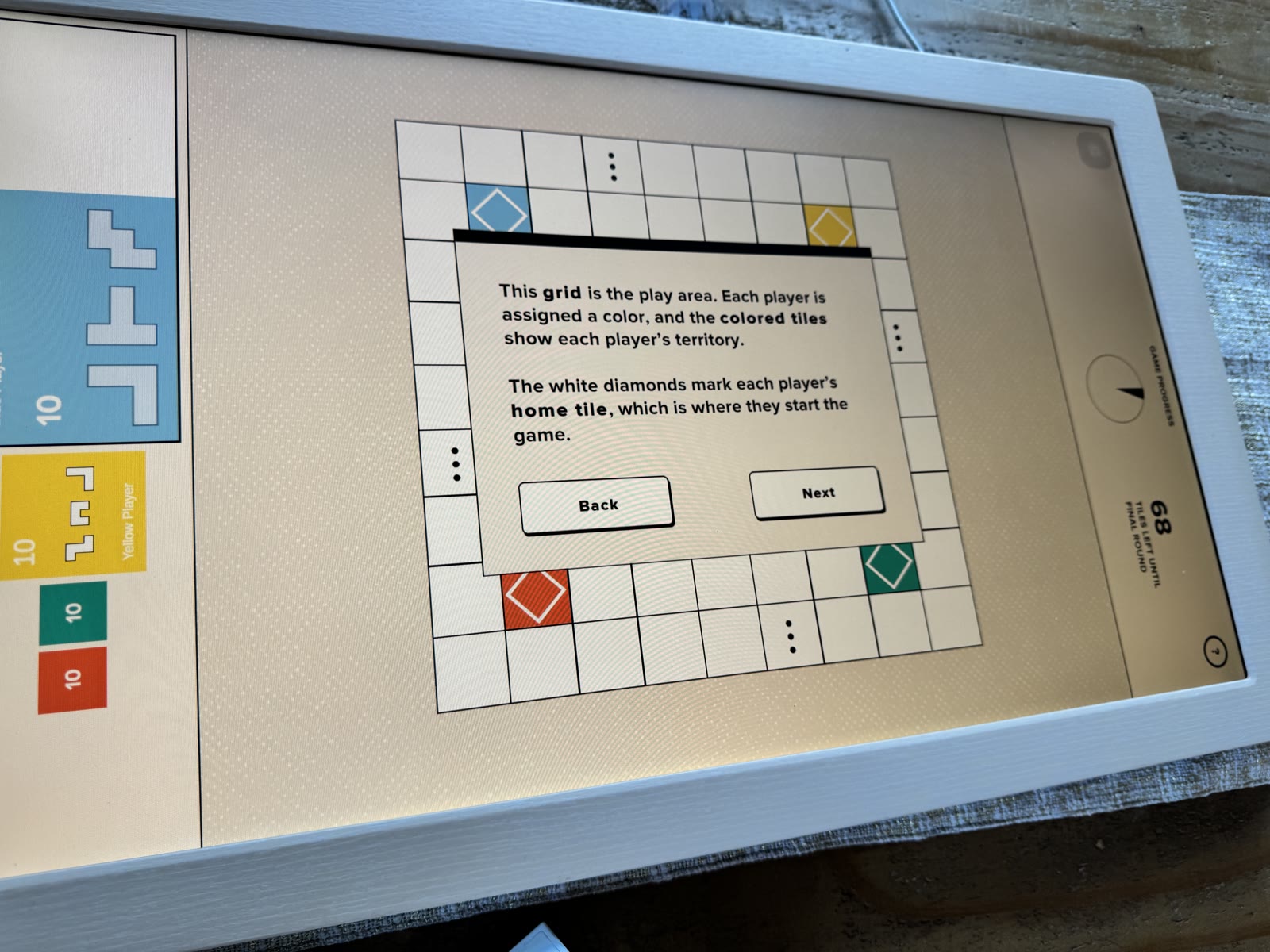 Tutorial overlay identifying the play grid and four colored home tiles.