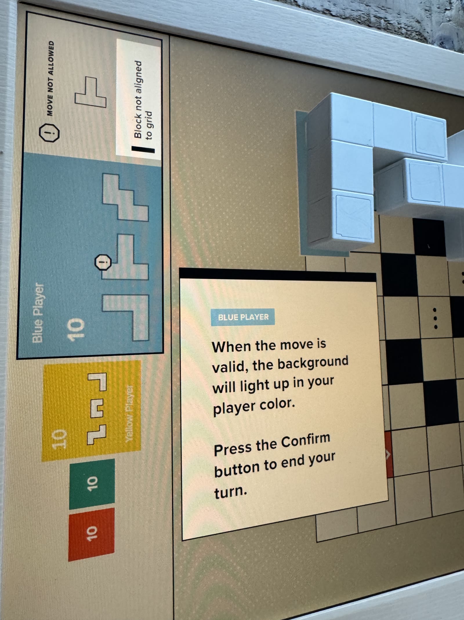 Blue valid-move tutorial with physical blocks and a contradictory side-panel warning.