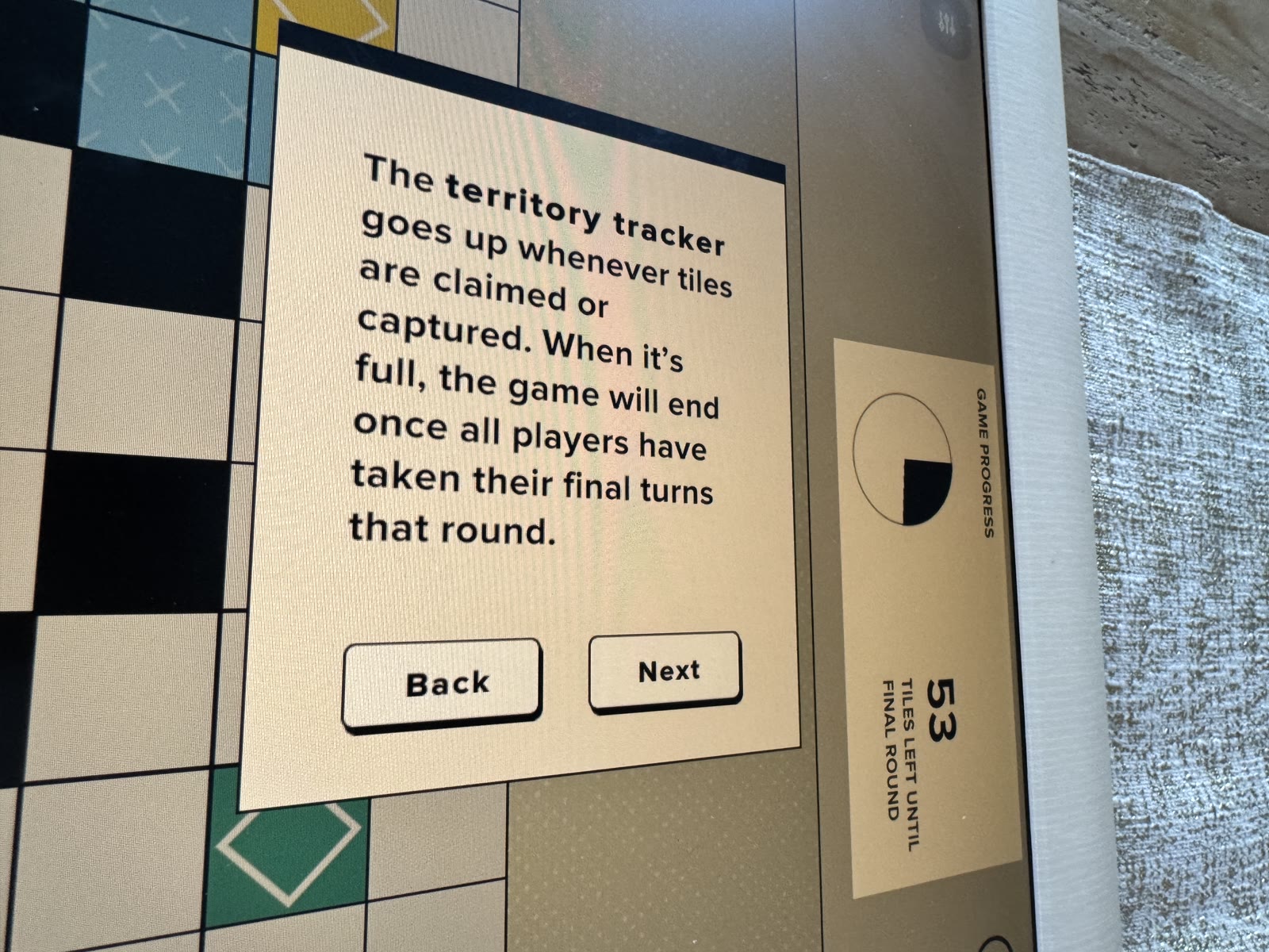 Tutorial overlay pointing to the territory progress tracker.